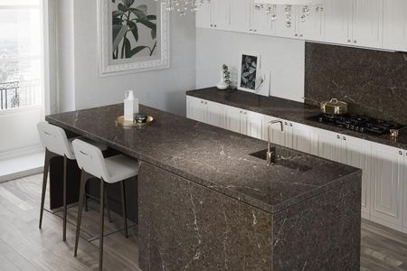 Eine moderne Küche mit einer marmorierten Insel und weißen Schränken.