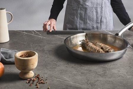 Ein Mann kocht an einer Küchenzeile und bereitet eine Mahlzeit zu.