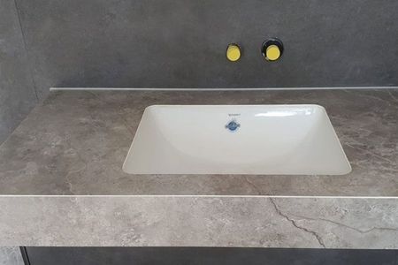 Badezimmerwaschbecken auf einem grauen Arbeitsplatte.