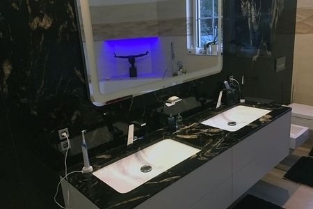 Badezimmer mit zwei Waschbecken und einem großen Spiegel über der Wand.