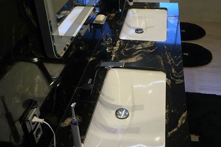 Badezimmer mit zwei Waschbecken und einem großen Spiegel über der Wand.
