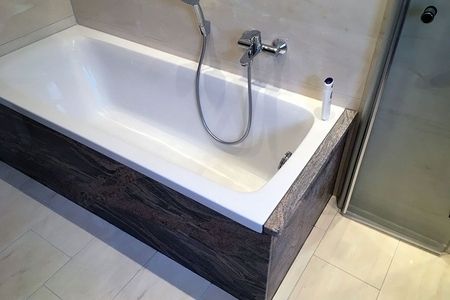 Badewanne mit Duschkopf und Waschbecken in einem modernen Badezimmer.